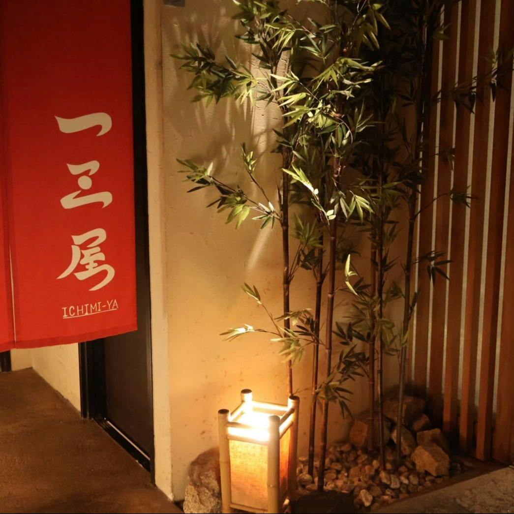 入口の赤い暖簾と、行灯に照らされた竹